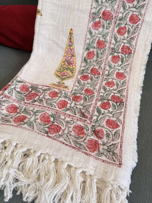 Decorative fabric with floral patterns and fringes on a plain background