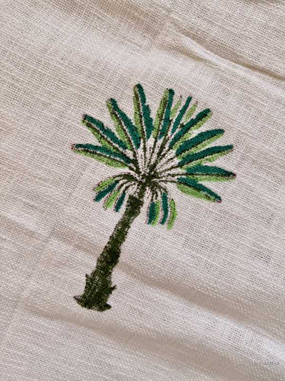 Embroidered palm tree design on a beige fabric background