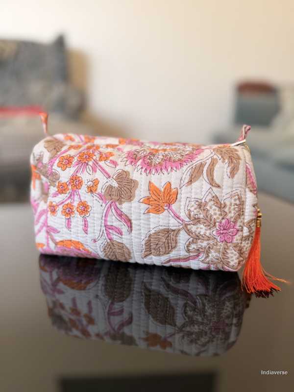 Floral-patterned pouch with tassel on a reflective surface | Paradise