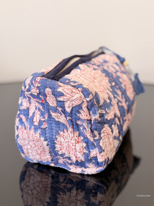 Floral patterned fabric bag on a reflective surface with a neutral background