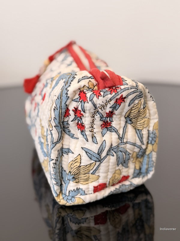 Decorative pouch with floral and butterfly pattern on a reflective surface