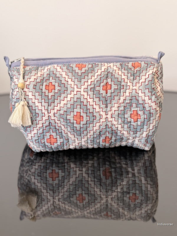 toiletry pouch with geometric pattern sitting on a glass surface