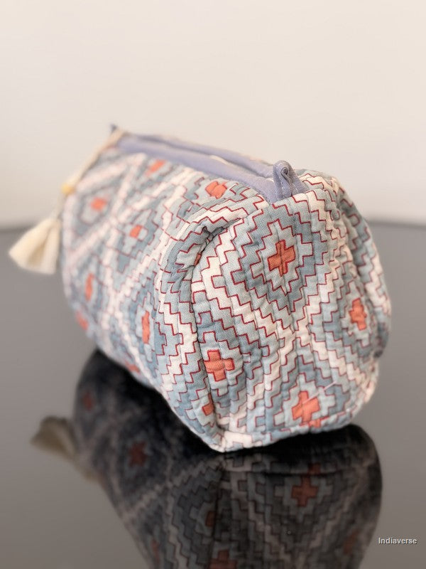 toiletry pouch with blue and red pattern sitting on a glass surface