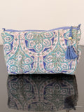 blue floral toiletry bag sitting on a glass surface