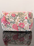Floral patterned pouch with tassels on a reflective surface