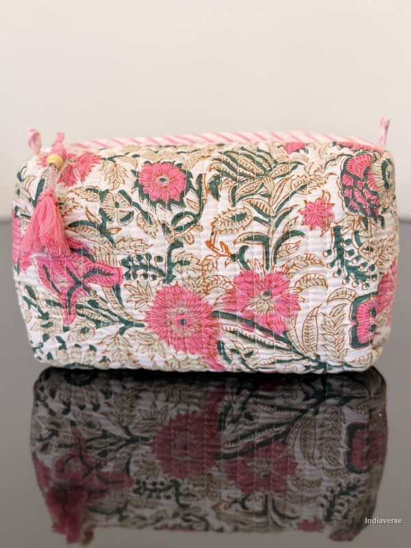 Floral patterned pouch with tassels on a reflective surface