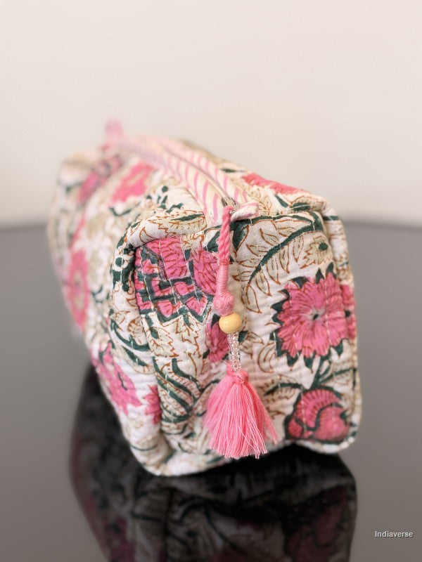pink floral toiletry bag sitting on a glass surface