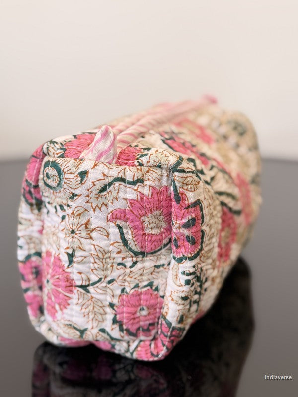 Pink floral toiletry bag sitting on a glass surface