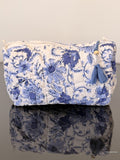 blue floral toiletry bag sitting on a glass surface