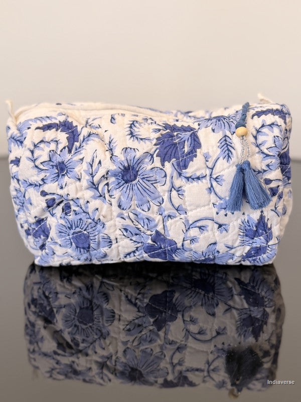blue floral toiletry bag sitting on a glass surface