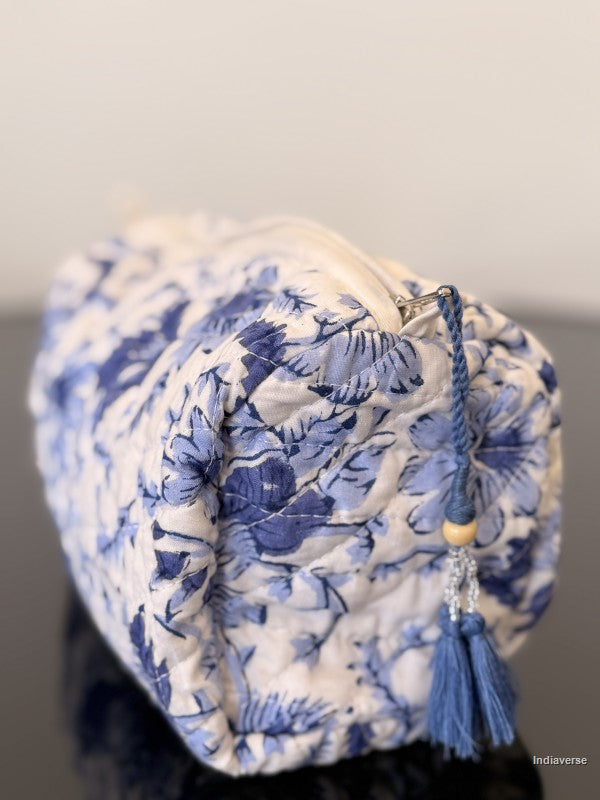 Blue floral-patterned fabric bag with tassel on a gray background