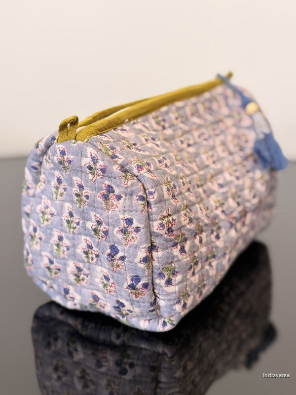 Floral-patterned pouch with a yellow zipper on a reflective surface