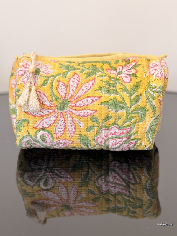 Floral patterned pouch with tassels on a reflective surface