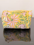 Floral patterned pouch with tassels on a reflective surface