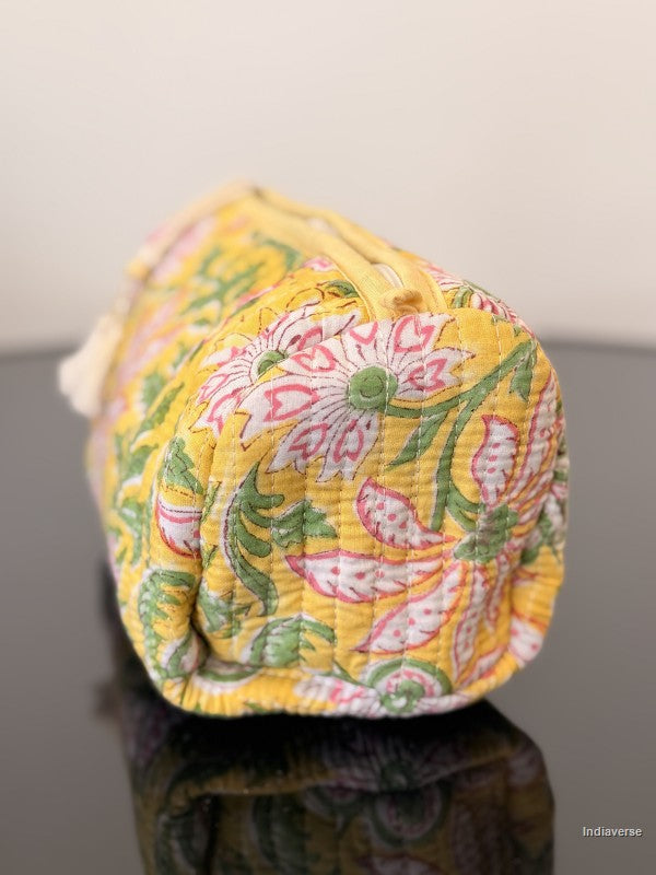Yellow fabric bag with floral pattern on a reflective surface