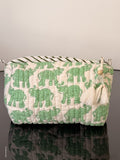 Green elephant-patterned pouch with tassels on a neutral background