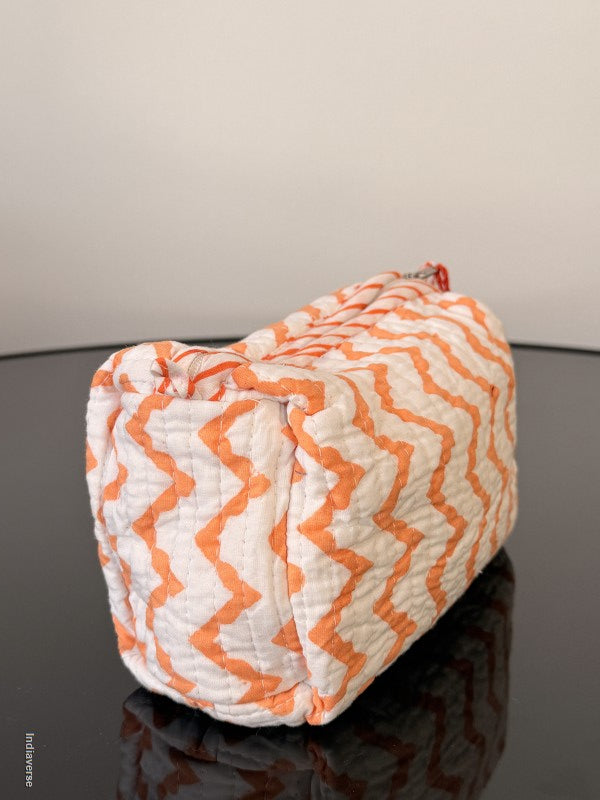 Orange and white zigzag patterned bag on a gray surface