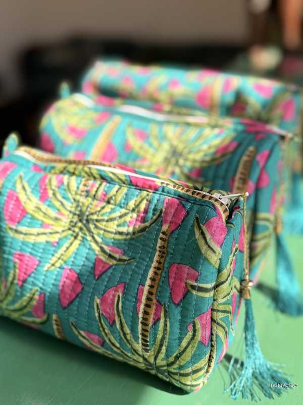 Fabric pouch with pink and green leaf pattern on a green surface | Tropical Bliss