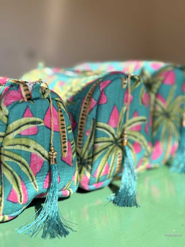 Decorative pillows with tropical palm tree pattern and tassels on a green surface | Tropical Bliss