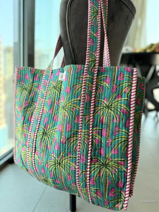 Tote bag with palm tree pattern held by a person indoors
