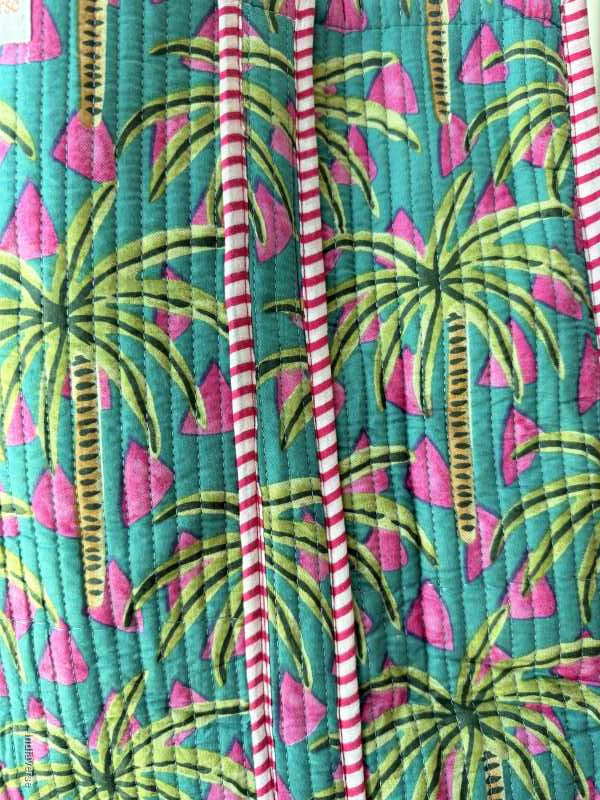 Fabric with tropical leaf pattern on a teal background