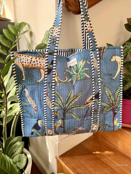 Tropical-themed tote bag with animal prints and stripes on a wooden surface.