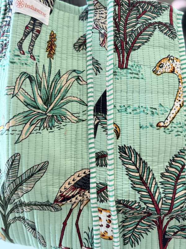Fabric with jungle-themed design featuring animals and plants, branded 'Indienne'.