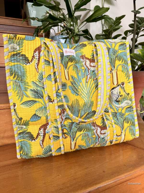 Yellow fabric tote bag with jungle animal pattern on a wooden surface