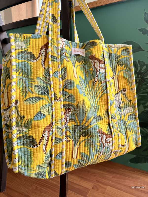 Yellow quilted tote bag with animal pattern hanging on a chair