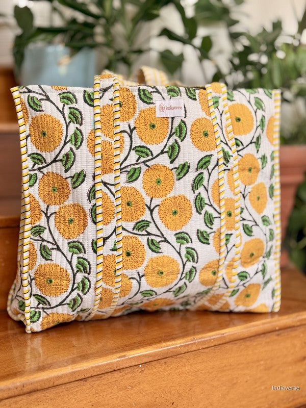 quilted tote bag with yellow flower design sitting on a wooden surface