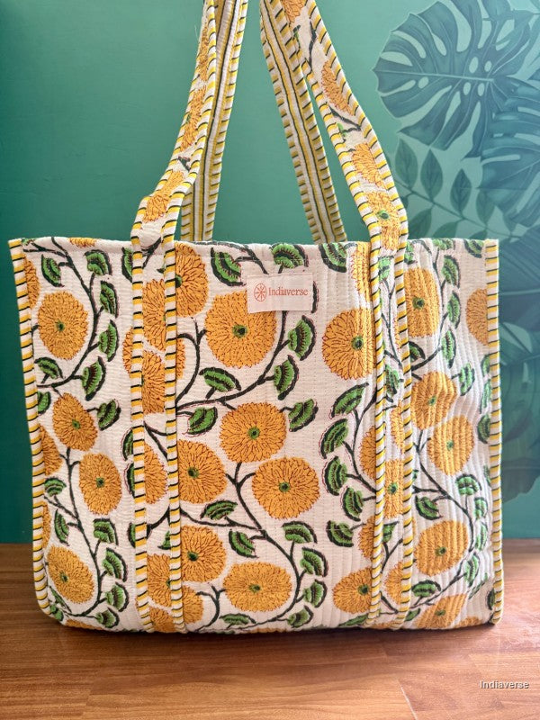 yellow flower tote bag sitting in front of a green wall